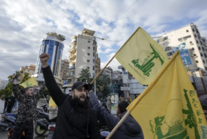 Residents celebrate carrying Hezbollah flags in Beirut, Lebanon. A ceasefire has been implemented between Israel and the Hezbollah group.